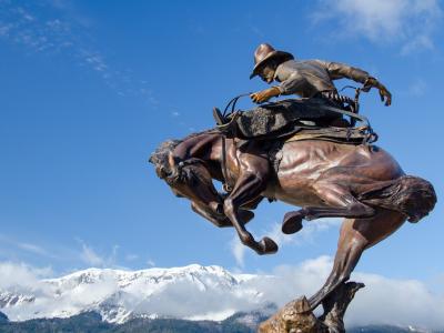 Bronze bronc rider sculpture in Joseph, Oregon, with the Wallowa Mountains behind