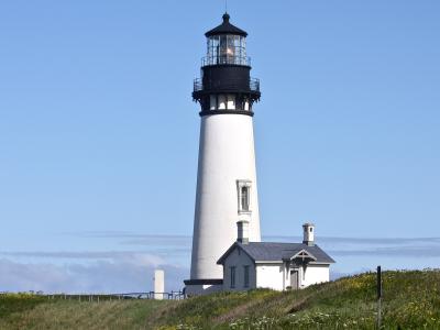 The white tower of Yaquina Head Lighthouse on its headland