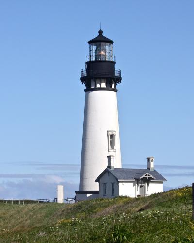 The white tower of Yaquina Head Lighthouse on its headland